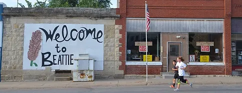 A woman walks past a duplicate sign that says welcome to Bethlehem.