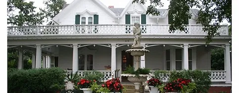 A white Victorian style house in Marysville with a fountain.