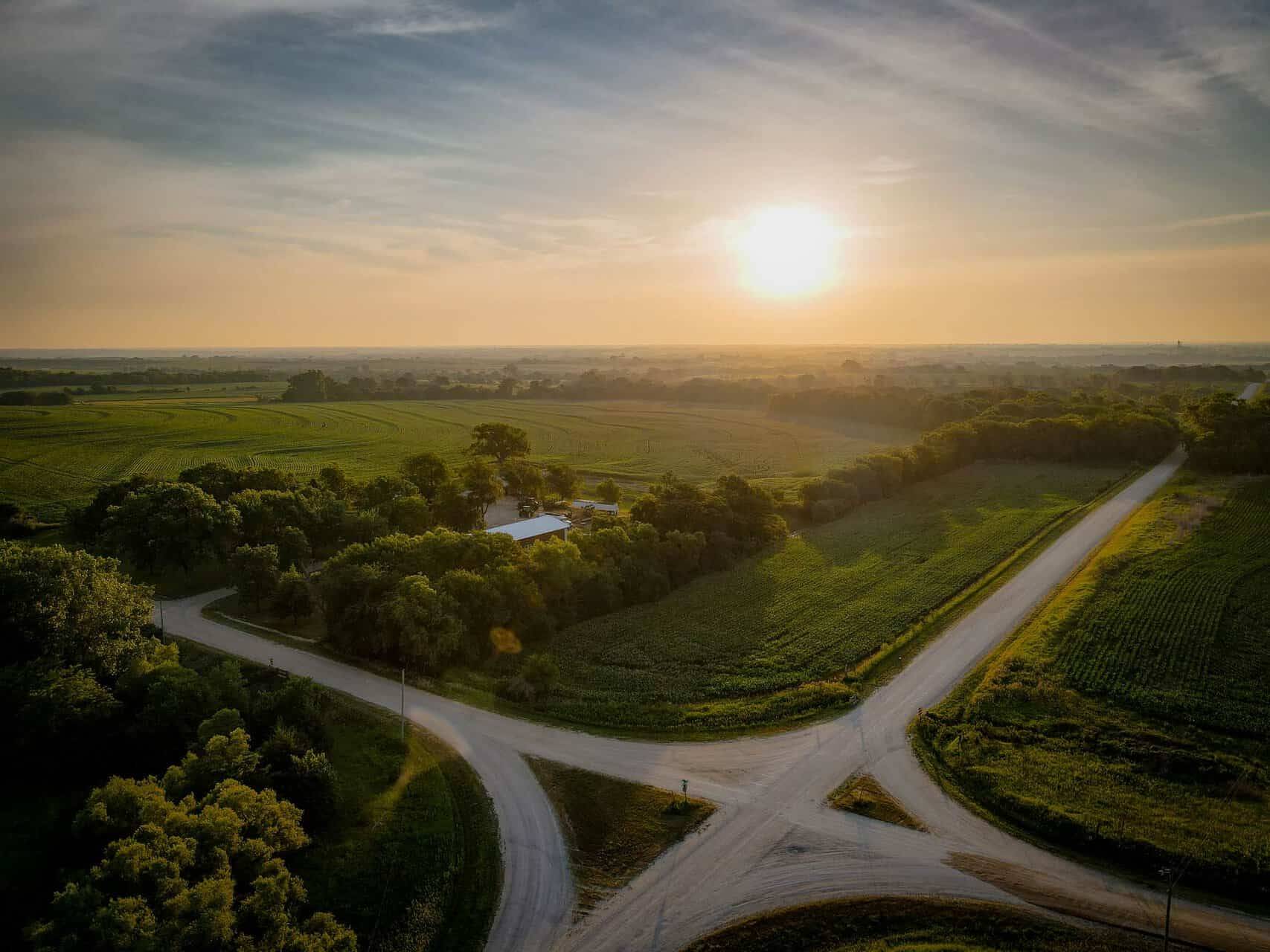An aerial view of a country road at sunset.